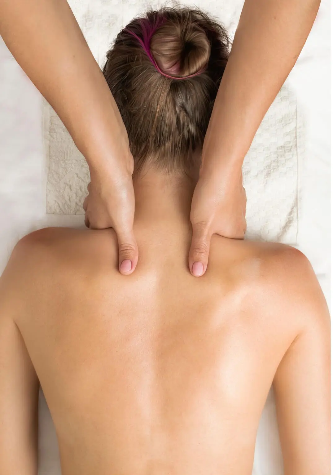 Sesión de masaje terapéutico — manos aplicando técnica profunda en espalda